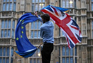 Лидеры Британии и ЕС готовы продолжать переговоры по Brexit до последнего - Мировая экономика Участник протеста против Brexit возле здания парламента в Лондоне