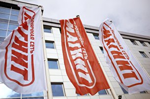 "Магнит" утвердил стратегию развития на пять лет - Потребрынок Корпоративные флаги перед головным офисом сети магазинов