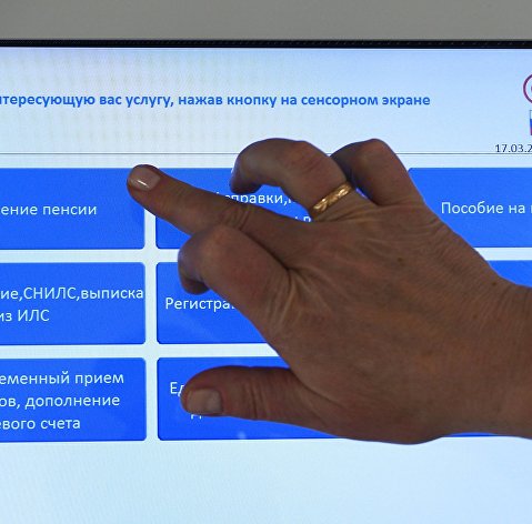 ПФР изменил срок перехода на карту "Мир" для получения пенсий Человек выбирает услугу в терминале в ПФР в Москве.