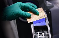 В Visa предрекли повсеместное использование биометрии при оплате - Новости экономики Покупатель оплачивает покупку банковской картой на кассе
