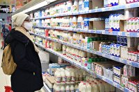 Россия ужесточает ответственность за отсутствие маркировки и ее подделку - Макроэкономика Покупательница выбирает товар в молочном отделе гипермаркета