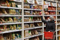 Эксперт объяснил, как удешевить органическую продукцию в России - Сельское хозяйство Покупательница выбирает макаронные изделия в гипермаркете