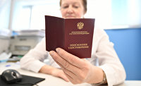 Сенатор предположила, как будут индексироваться пенсии и соцвыплаты - Пенсии Сотрудница ПФР держит в руках пенсионное удостоверение